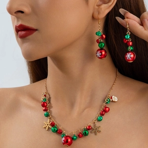 Close-up of Christmas jewelry set with red and green bells and golden snowflake charms