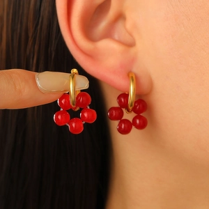 Vintage red flower beaded hoop earrings in gold finish worn by a model