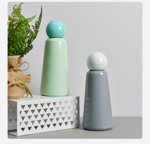 Detail of insulated stainless steel water bottles in light blue and grey matte finish