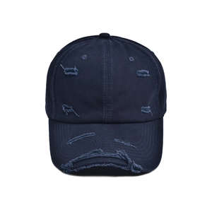 Close-up of distressed denim baseball cap detailing worn edges and torn fabric textures