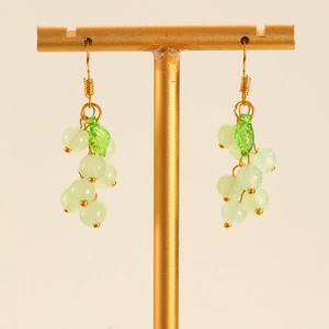 Detailed view of grape cluster earrings with light green beads and gold wire hooks