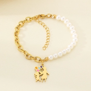 Detail of gold titanium bracelet with pearls and a figure holding balloons charm