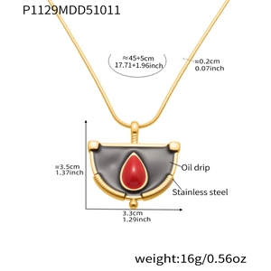 Détail du collier en acier doré avec pendentif goutte rouge et chaîne serpent fine