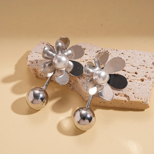 Detail of silver flower earrings with white pearls and hanging mirror metal spheres