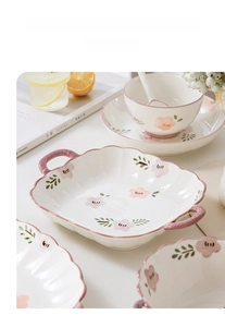 Close-up of hand-painted floral ceramic tableware set with underglaze pink flowers