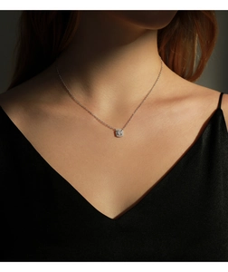 Detail of 1ct moissanite square halo pendant necklace worn on a woman's neck