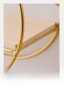 Detail of Nordic wall shelf featuring light solid wood and golden metal ring frame