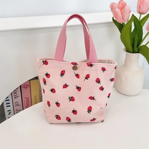 Détail du sac cabas en velours côtelé rose avec imprimés fraises et fermoir pression