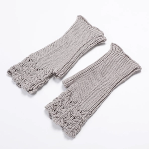 Detail of grey knitted fingerless gloves with intricate scale pattern and scalloped edges