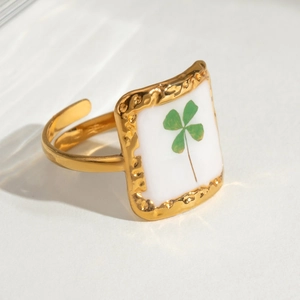 Detailed view of adjustable gold flower ring with clover pattern and hammer texture