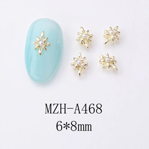 Détail de bijoux d'ongles étoile en alliage doré 6x8mm avec perle sur manucure bleue