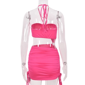 Back view of a rose pink two-piece set with halter neck top and drawstring mini skirt