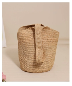 Detail of natural raffia weave texture on a spacious bucket shoulder bag for beach vacations