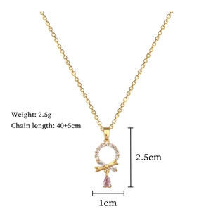 Detail of gold necklace with bow pendant, sparkling white zircon and pink teardrop gemstone