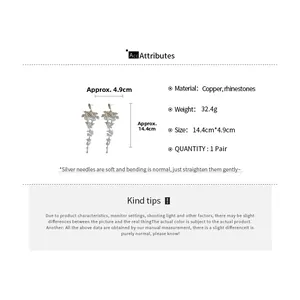 Detailed view of silver needle drop tassel earrings with rhinestones and copper material