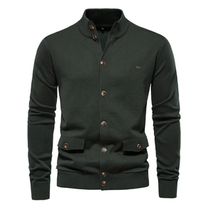 Detail of dark green knit cardigan featuring metal logo badge and buttoned pocket flaps