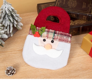 Detail of Santa Claus felt gift bag with 3D elements on a festive wooden surface