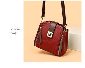 Close-up of wine red bucket bag with vintage leather texture and gold hardware detail