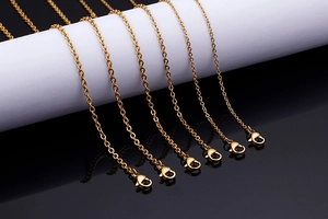 Detailed view of multiple gold punk style chain necklaces with lobster clasp closures