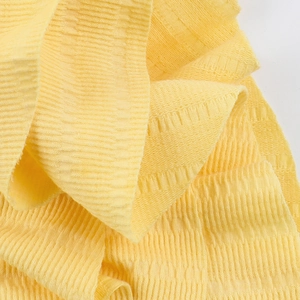 Macro shot of bright yellow knitted fabric with hollow vertical stripes texture