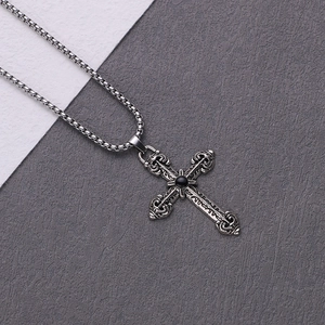 Detailed view of vintage silver cross pendant with black stone on a silver box chain
