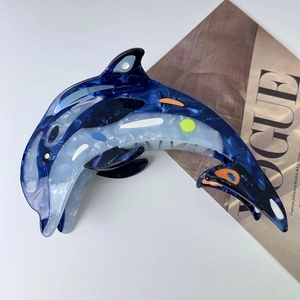 Détail de la pince à cheveux dauphin en acétate avec texture marbrée et design marin