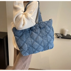 Détail du grand sac fourre-tout en jean bleu matelassé avec surpiqûres en diamant