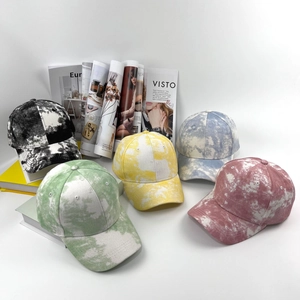 Collection de cinq casquettes de baseball tie-dye colorées sur des magazines
