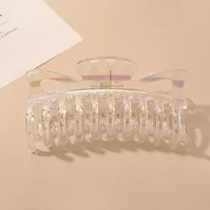 Macro detail of iridescent transparent hair claw clip with strong metal spring mechanism