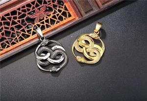 Detailansicht der ineinander verschlungenen Ouroboros-Schlangenanhänger in Gold und Silber