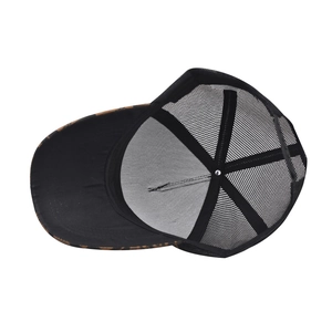 Detail of breathable black mesh trucker hat with adjustable snapback and interior stitching