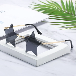 Frameless star shaped sunglasses with grey lenses and gold metal temples on marble decor