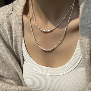 Detail of elegant double-layered pearl necklace worn with minimalist casual attire