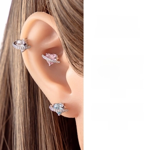 Detailed close-up of heart-shaped saturn stud earrings with sparkling crystals