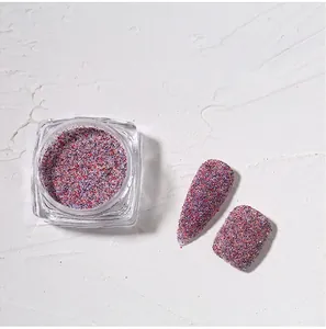 Macro shot of colorful nail glitter powder in a jar with textured sand finish nail tips