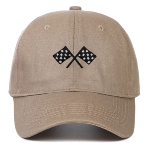 Close-up of checkered flag embroidery on a tan cotton baseball cap with fine stitching