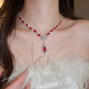 Close-up of luxury silver flower necklace with red teardrop crystal on model neck