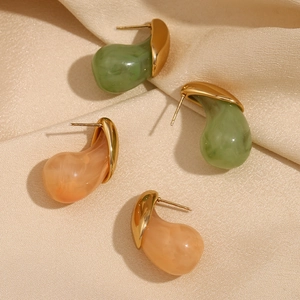 Detailed macro view of green and pink marble resin studs on champagne velvet fabric