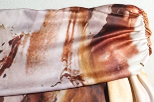 Détail du tissu à motif marbré avec poignets plissés élastiques sur une robe marron