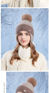 Detail view of winter knitted ear protection hat with plush pompom and color-block design