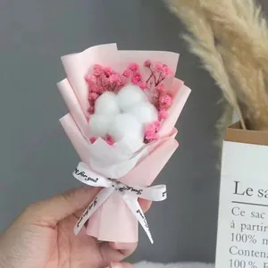 Close-up of mini flower bouquet with pink baby's breath and cotton in pink paper