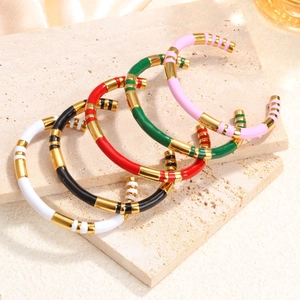 Luxe enamel stainless steel bamboo-style open bangles in five vibrant colors displayed on stone
