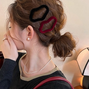 Elegant flocked wavy hair clips in black and wine red worn by a woman for a chic look