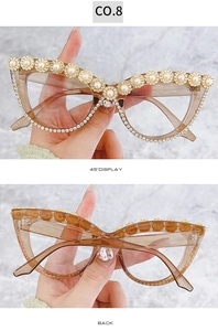 Dettaglio occhiali da sole cat-eye con decorazioni floreali dorate e perle