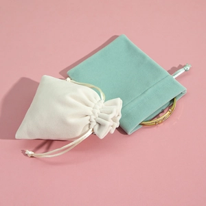 Macro view of plush velvet jewelry drawstring pouches in white and mint green colors