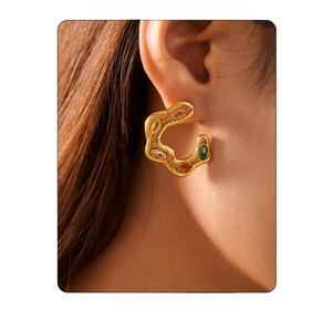 Detailed close-up of golden lava texture C-shape earrings with colorful zircons on a model
