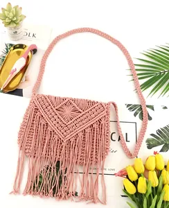 Detail der rosa Makramee-Umhängetasche mit Boho-Fransen und gewebtem Schultergurt