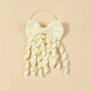 Close-up of a cream-colored grosgrain ribbon bow with hanging spiral curls for girls