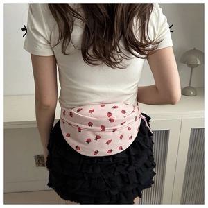 Detail of pink corduroy shoulder bag with red strawberry print shown on model