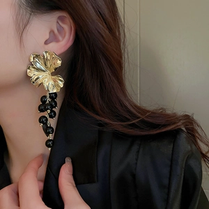 Macro shot of gold ginkgo leaf and black beaded cluster tassel earrings for women